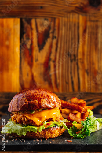 Fresh craft burger on a rustic wooden background. French fries on the side 