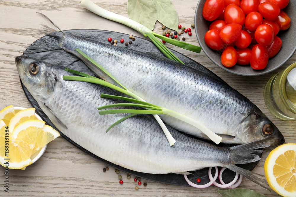 Salted herrings, spices and tomatoes on wooden table, flat lay Salted herrings, spices and tomatoes on wooden table, flat lay