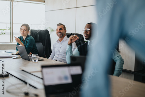 A diverse group of business people actively participate in a collaborative meeting. The atmosphere is focused and engaged, reflecting teamwork and open communication. Ideal for concepts of diversity photo