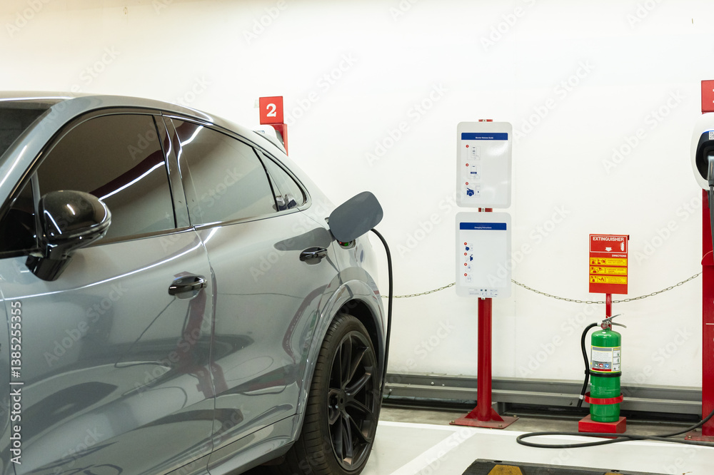 Fototapeta premium Charging for electric car with a public charger in a parking.Station of power cable pump plug in charging power to electric vehicle EV car.Green eco energy for save the earth concept.