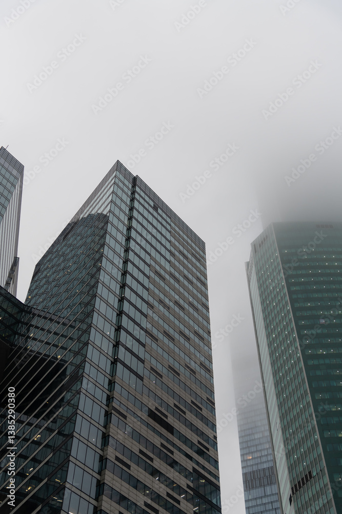 Skyscrapers enveloped in fog showcasing urban architecture and misty atmosphere Skyscrapers enveloped in fog showcasing urban architecture and misty atmosphere