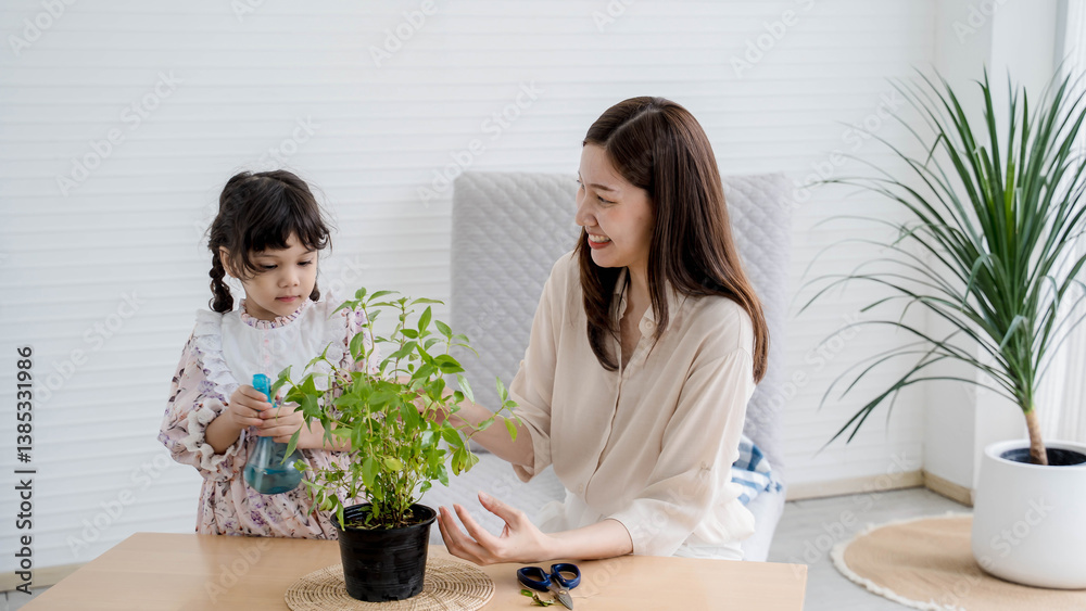 Mother and daughter bonding while watering potted plant together indoors, teaching environmental care and enjoying relaxing home gardening activity. Mother and daughter bonding while watering potted plant together indoors, teaching environmental care and enjoying relaxing home gardening activity.