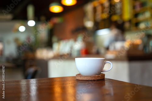 White hot coffee cup on table in coffee shop with blurred background