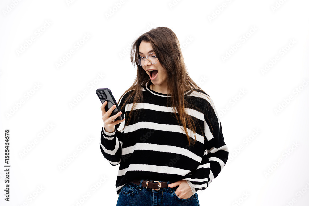 A woman is surprised and excited to receive pleasant or shocking notifications on her cell phone. Cell phone concept, positive news. A woman is surprised and excited to receive pleasant or shocking notifications on her cell phone. Cell phone concept, positive news.