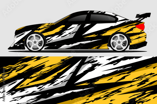 Stylishly designed racing car with a striking black, white, and yellow graphic wrap on a gray background