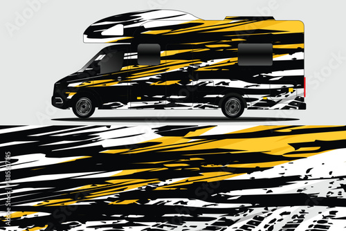Sleek, modern camper van with striking black and yellow abstract design parked against a neutral backdrop