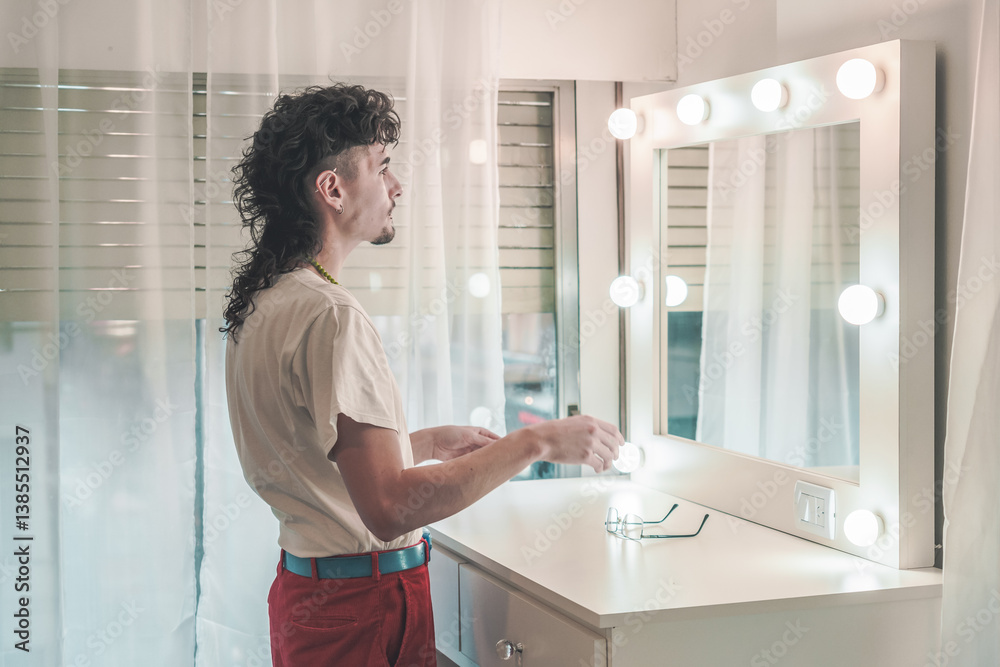 Young man with mullet hairstyle preparing in front of mirror with lights getting ready in the morning at home Young man with mullet hairstyle preparing in front of mirror with lights getting ready in the morning at home