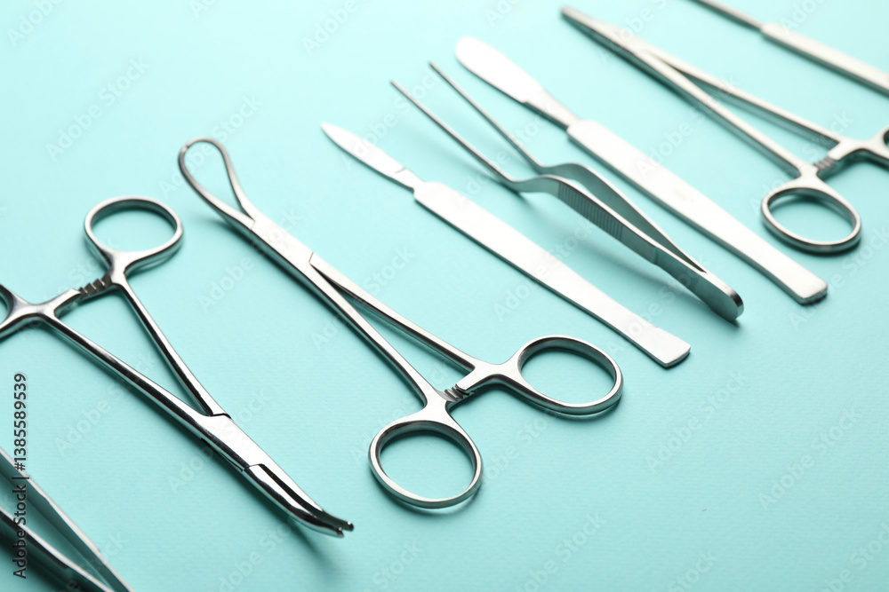 Different surgical tools on turquoise background, closeup Different surgical tools on turquoise background, closeup