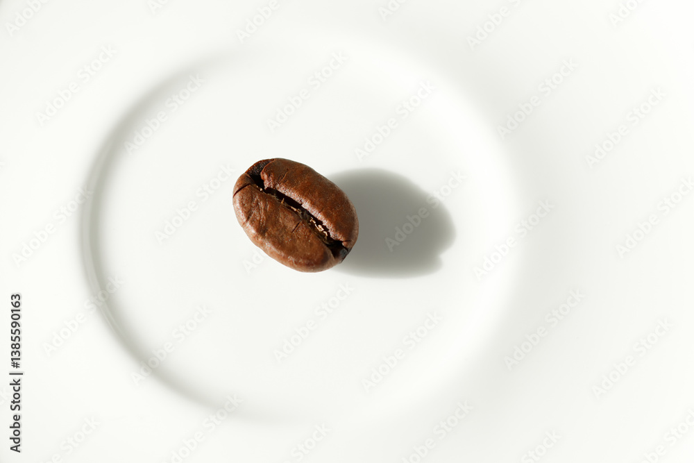 A single coffee bean placed on a white background, captured in a minimalist style. Perfect for themes like simplicity, purity, focus, or premium coffee branding