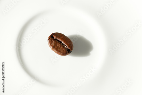 Obraz na płótnie A single coffee bean placed on a white background, captured in a minimalist style. Perfect for themes like simplicity, purity, focus, or premium coffee branding w salonie