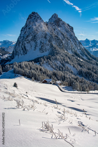 The large and small Mythen mountains photographed on a snowshoe tour at Haggenegg. With a freshly snow-covered landscape and the approaching sunset.