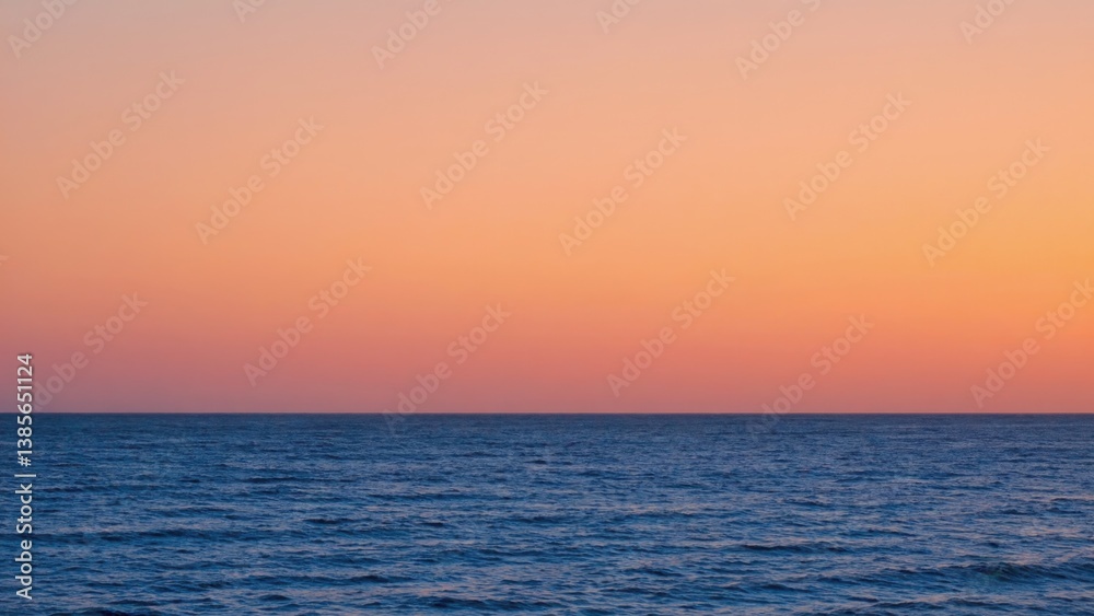 Fototapeta premium A serene ocean sunset with a calm horizon and clear water.