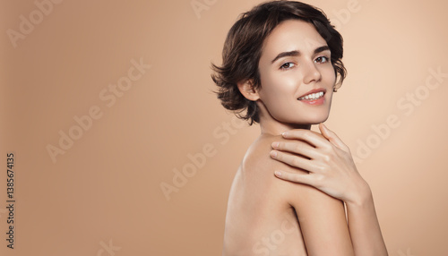 Wellness and beauty concept. Portrait of beautiful, tender young woman after shower, has glowy radiant skin without blemishes, covers herself with hands and looks at camera, brown background