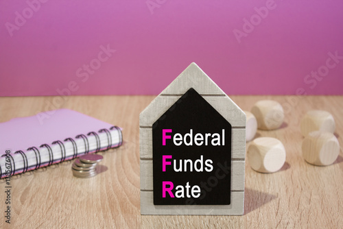 Obraz na płótnie FEDERAL FUNDS RATE symbol. Black board with words FEDERAL FUNDS RATE. Beautiful purple background. Notebook and silver coins on the table. Business concept. w salonie