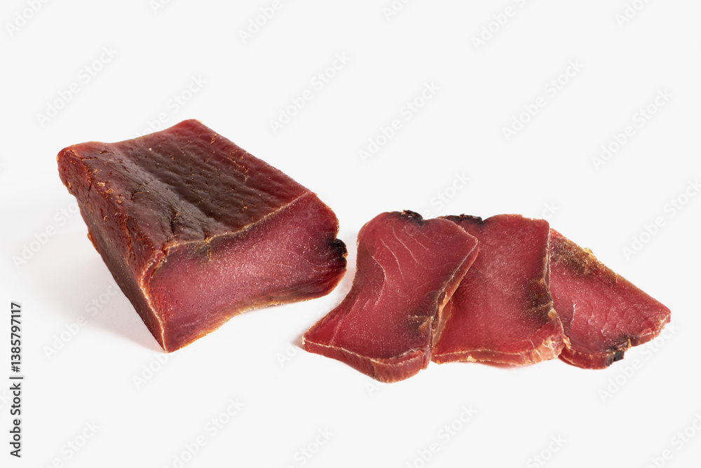 Mojama, salt-cured tuna loin, a piece and several sliced pieces, on a white background, close-up.
