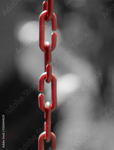 Obraz na płótnie Artistic composition with a red plastic chain and a black and white blurred background. Bokeh. w salonie