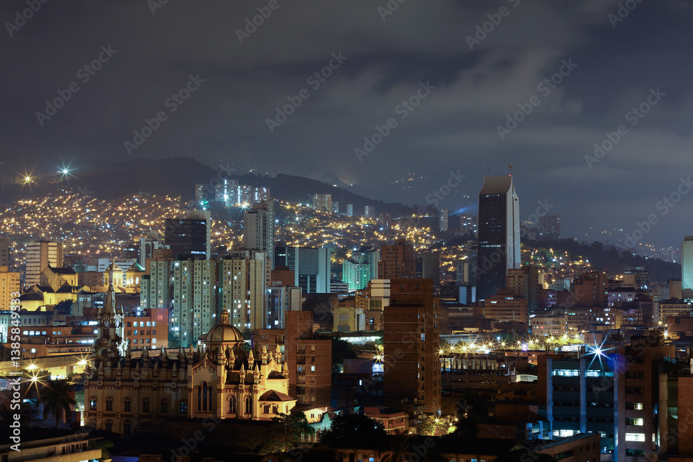 Breathtaking night view of Medellín, Medellin, Antioquia, Colombia, with illuminated skyscrapers and historic architecture. The city glows against the Andean mountains, creating a urban landscape.