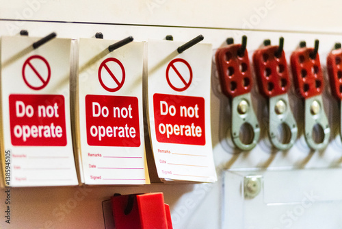 A close-up of a 'lockout station' displaying safety equipment and safety warning signs, used to securely lock out valves and other machinery during maintenance. 