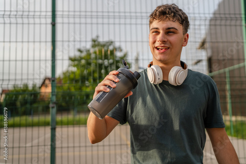 one young caucasian man teenager hold supplement shaker stand outdoor