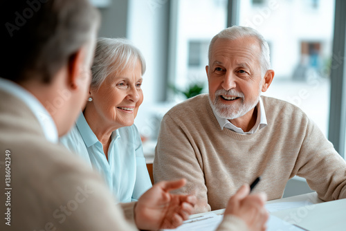 Elderly couple meeting with a consultant, smiling and discussing financial or legal matters