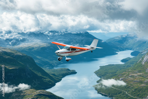 A small plane is flying over a beautiful landscape with a large body of water