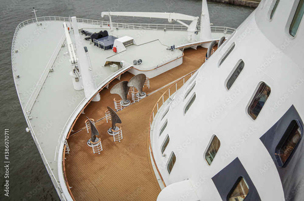 Views onto outdoor teak balcony terrace veranda promenade boat deck of ocean liner cruiseship cruise ship with chairs and loungers at sea during Transatlantic Crossing to New York on beautiful sun day