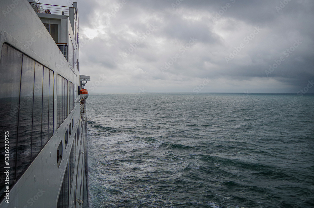 Views onto wet outdoor teak balcony terrace veranda promenade boat deck of ocean liner cruiseship cruise ship with chairs and loungers at sea during