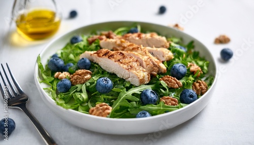 healthy salad with arugula blueberries and walnuts featuring grilled chicken and herbs on a white table nutritious option for clean eating
