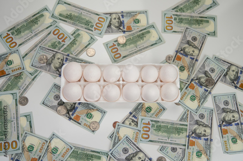 Chicken white eggs lie next to a stack of bills. Hundred-dollar bills are on the table with chicken eggs. Food inflation and the rise in price of chicken eggs