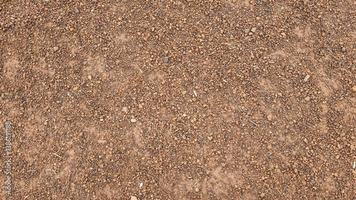 Fototapeta Naklejka Na Ścianę i Meble -  Brown small stone floor texture background. Rural roads or pavements are used for travel. Close-up aerial view of rough brown soil with no vegetation.