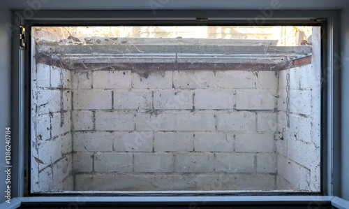 Obraz na płótnie Window overlooking a small, dirty, white brick basement with spiderwebs and rusty metal grate w salonie