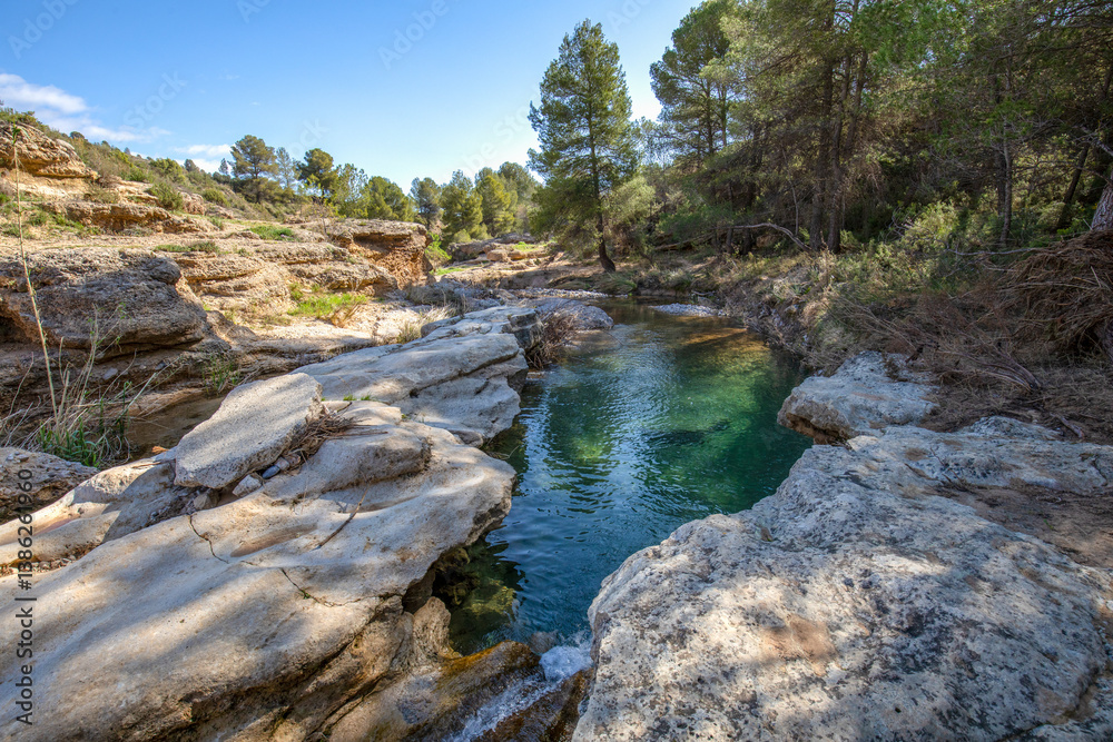 View of the emerald green pools of the Mula River in Bullas, Murcia Region, Spain, between large rocks View of the emerald green pools of the Mula River in Bullas, Murcia Region, Spain, between large rocks