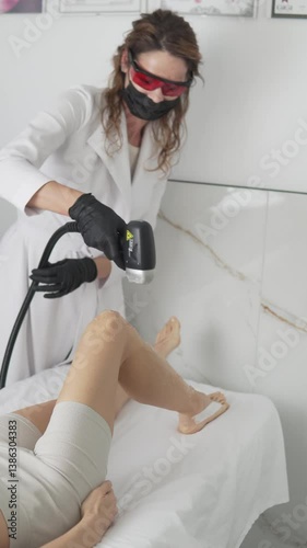 Laser hair removal of legs on a modern soprano laser titanium device in a beauty salon