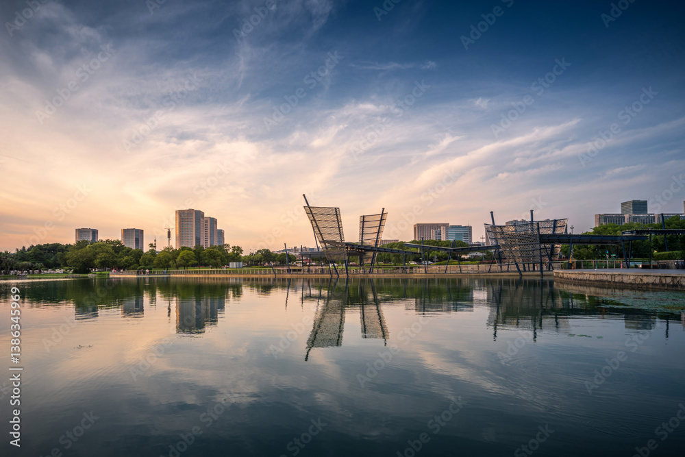 Naklejka premium Modern City Skyline at Sunset Reflected on Water