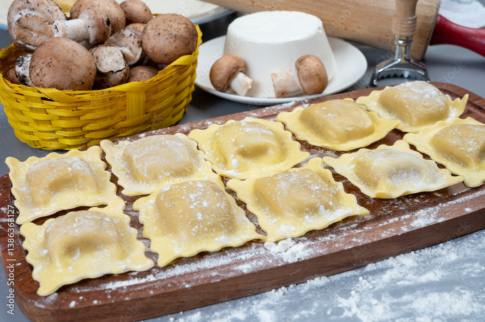 Fototapeta premium Italian food, fresh home made stuffed pasta ravioli dumplings with ricotta soft cheese and champignons porcini mushrooms, Parma, Emilia Romagna, Italy