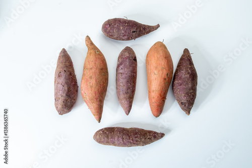 Colorful sweet-tasting tuberous roots vegetables purple and orange organic sweet potatos close up