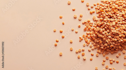 Pile of dried lentils scattered naturally on pale be