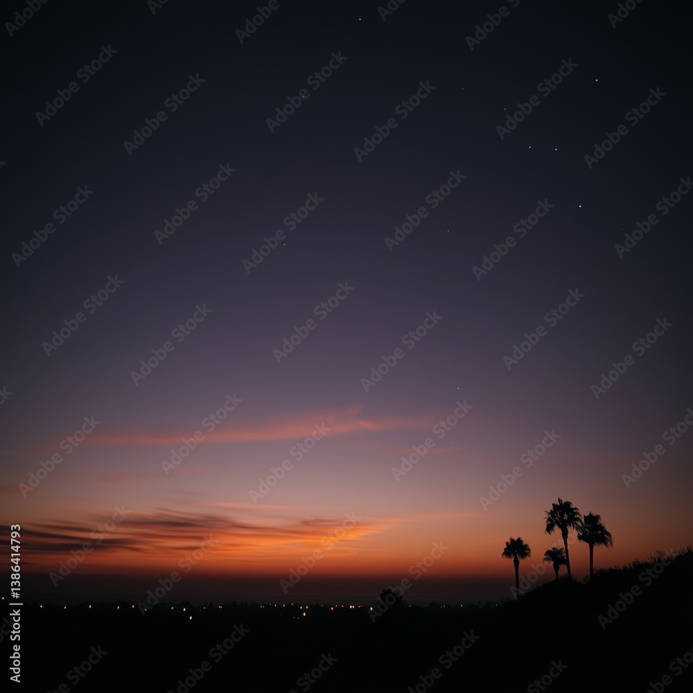 Fototapeta premium Tranquil dusk sky with silhouetted palm trees and city lights on horizon