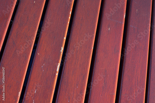 Close-Up of Weathered Wooden Planks
Detailed view of reddish-brown wooden planks with visible wear and scratches, showcasing texture and linear pattern in natural light.
