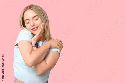 Young woman hugging herself...