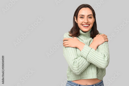Young woman hugging herself...