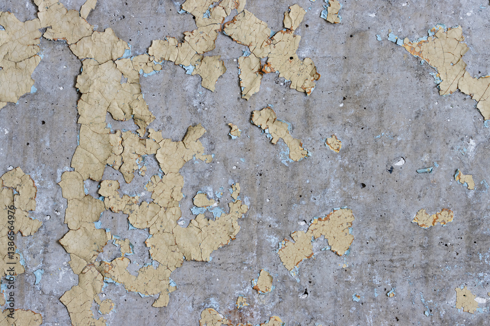 Peeling paint on the wall. Old concrete wall with cracked flaking paint. Weathered rough painted surface with patterns of cracks and peeling. High resolution texture for background and design. Closeup