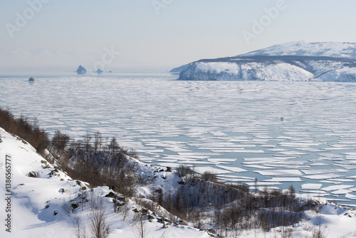 Obraz na płótnie Spring drift of ice floes in Gertner Bay. Sea of Okhotsk. Magadan Region, Russia. Ice in the sea bay began to split and crack. Fishermen's cars were carried out to sea on broken-off ice floes. w salonie