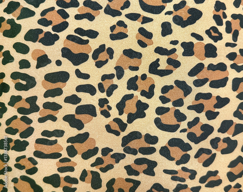 Close up of a graphic background with leopard skin pattern in yellow, brown, and black color. Animal skin leopard texture seamless background.