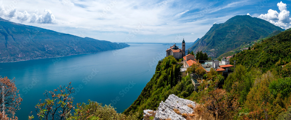 Lake Garda (Lago di Garda) with famous pilgrimage church Madonna di Montecastello high above in the mountains near Tignale in Italy