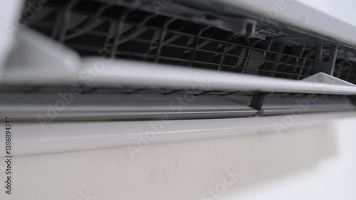 Wall-mounted air conditioner that distributes cool air throughout the room. Fan swing mechanism for comfortable air circulation.