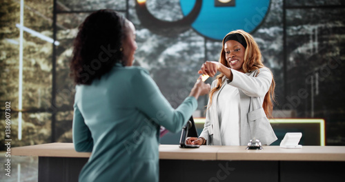 Busy African American woman checking into hotel reception desk