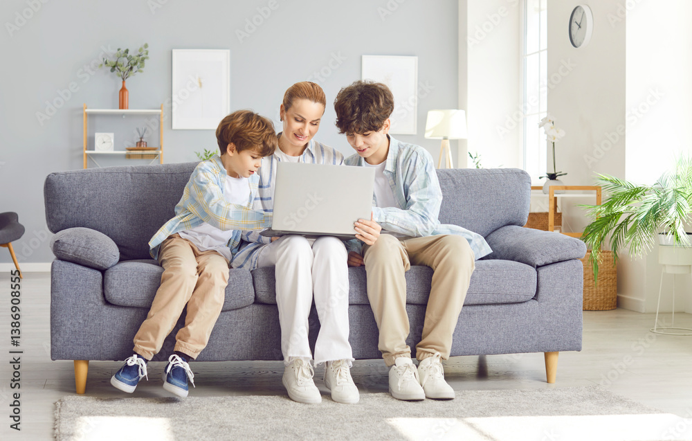 Mom with two sons sitting on the couch with a laptop, close-up. Happy teenagers spend time at home with their mother. Online family shopping concept, childrens safety on the Internet Mom with two sons sitting on the couch with a laptop, close-up. Happy teenagers spend time at home with their mother. Online family shopping concept, childrens safety on the Internet