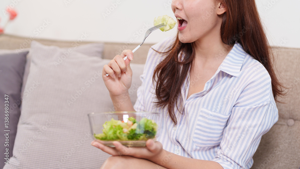 Healthy Diet: A woman enjoys a fresh salad, embracing a balanced and nourishing lifestyle. The scene is simple yet tells of health and well-being. Healthy Diet: A woman enjoys a fresh salad, embracing a balanced and nourishing lifestyle. The scene is simple yet tells of health and well-being.