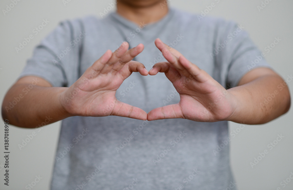 Child's hands make a heart shape.